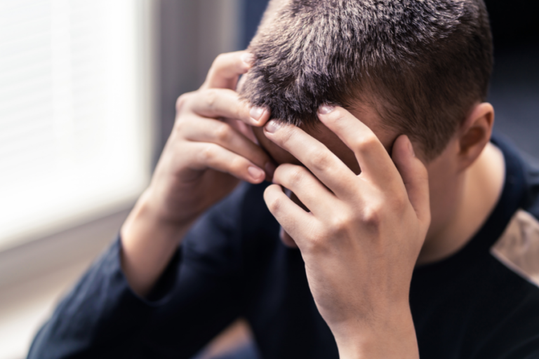 A man holding his head in his hands.